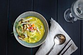 Golden Fennel Soba Noodle Soup is served with quick pickled veggies and white wine on a black wooden background