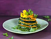 A zucchini and sweet potato tower with parsley