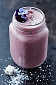 Blueberry smoothie with coconut and edible flowers