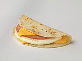 A tortilla with cheese, an egg white omelette, and sausage