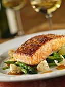 A salmon fillet in lemon sauce with spring vegetables