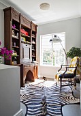 Large hand-crafted bureau and zebra-skin rug in living area