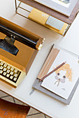 Postcard and notebook next to old typewriter