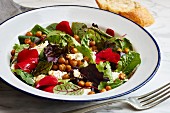 Green salad with sheep's cheese, baked chickpeas and edible petals