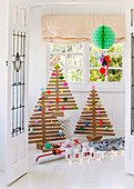 Christmas trees made of wooden slats with colorful paper decorations