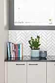 White kitchen counter with white herringbone-tiled splashback