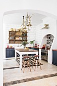 Large table and bar stools in centre of Mediterranean kitchen