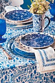 Gedeckter Tisch im blau-weißen Mustermix