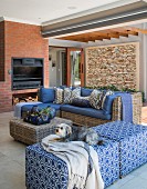 Wicker furniture and open fireplace in brick wall in comfortable lounge area