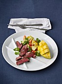 Grilled entrecote with a salad of papaya, mango, cucumber, tomatoes and coriander green