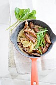 Fried liver with onions and mint in a frying pan