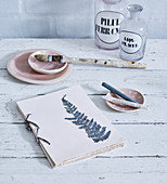 Pressed and painted fern leaf on hand-tied book