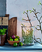 Pressed fern leaf in candle lantern amongst rustic accessories made from natural materials