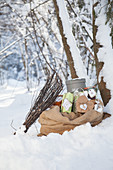 Besom broom leant on sack of presents in snowy landscape