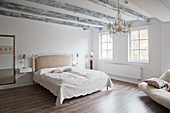Large, white bedroom with simple furnishings