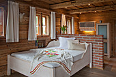Embroidered blanket on bed in rustic bedroom