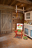 Loose cover embroidered with tulips on red chair in country-house kitchen