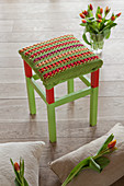 Crocheted seat cover on red and green stool