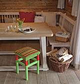 Crocheted seat cover on red and green stool next to dining table