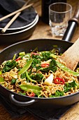 Asian wok noodles with kale, sugar snap peas, spring onions, and chili peppers