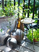 Stone ball, planter, metal stand and collection of flotsam on balcony