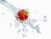 A strawberry with a splash of water