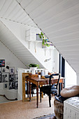 Antique desk at head of stairs next to dormer window