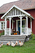 Chickens next to steps leading to veranda of Swedish house