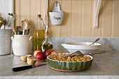 Apples and pie in dish on marble kitchen worksurface