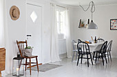 Dining table and spoke-back chairs in foyer next to front door