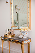 Mirrored table below mirror in Venetian style on bedroom wall