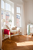 Sheepskin on Baroque couch below window in round room of period interior