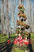 Girl sitting under stylised Christmas tree decorated with protea flowers amongst bare trees