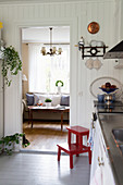 Blick von skandinavischer Landhausküche ins klassische Wohnzimmer