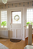 Haustür und Spossenfenster im Eingangsbereich im skandinavischen Landhausstil