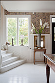 Dog sitting on stairs in elegant foyer with white floor