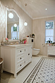Classic washstand in white bathroom with patterned tiles