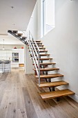 Moderne Treppe mit Holzstufen im modernen Wohnraum mit Küche