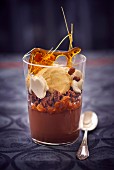 A chocolate and caramel dessert with vanilla ice cream in a glass