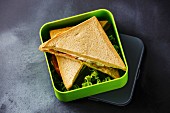 Sandwiches in Lunch-Box vor grauem Hintergrund