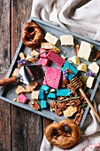 Variety of colorful holland cheese traditional soft, old, pink basil, blue lavender, pecan nuts, honey, lavender flowers, pretzels bread