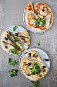 Trio of pizzas: with tomato, mozzarella, artichoke, with Parma ham, asparagus, olives and with goat cheese, apple, walnuts, olives