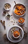 Carrot Halwa (Carrot pudding) with nuts in a ceramic bowl on top view on a marble table