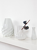 weiße Vasen mit Struktur auf einem Regalbrett