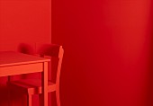 Roter Tisch und roter Stuhl vor roten Wänden