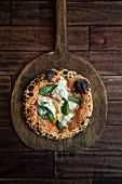 Neapolitan pizza with burrata, olive oil and basil (seen from above)