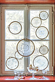 Lace doilies mounted in embroidery frames decorating window