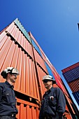 Two industrial workers with shipping containers