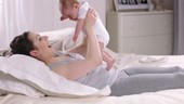 Mother on bed with baby