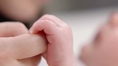 Baby grasping parent's finger